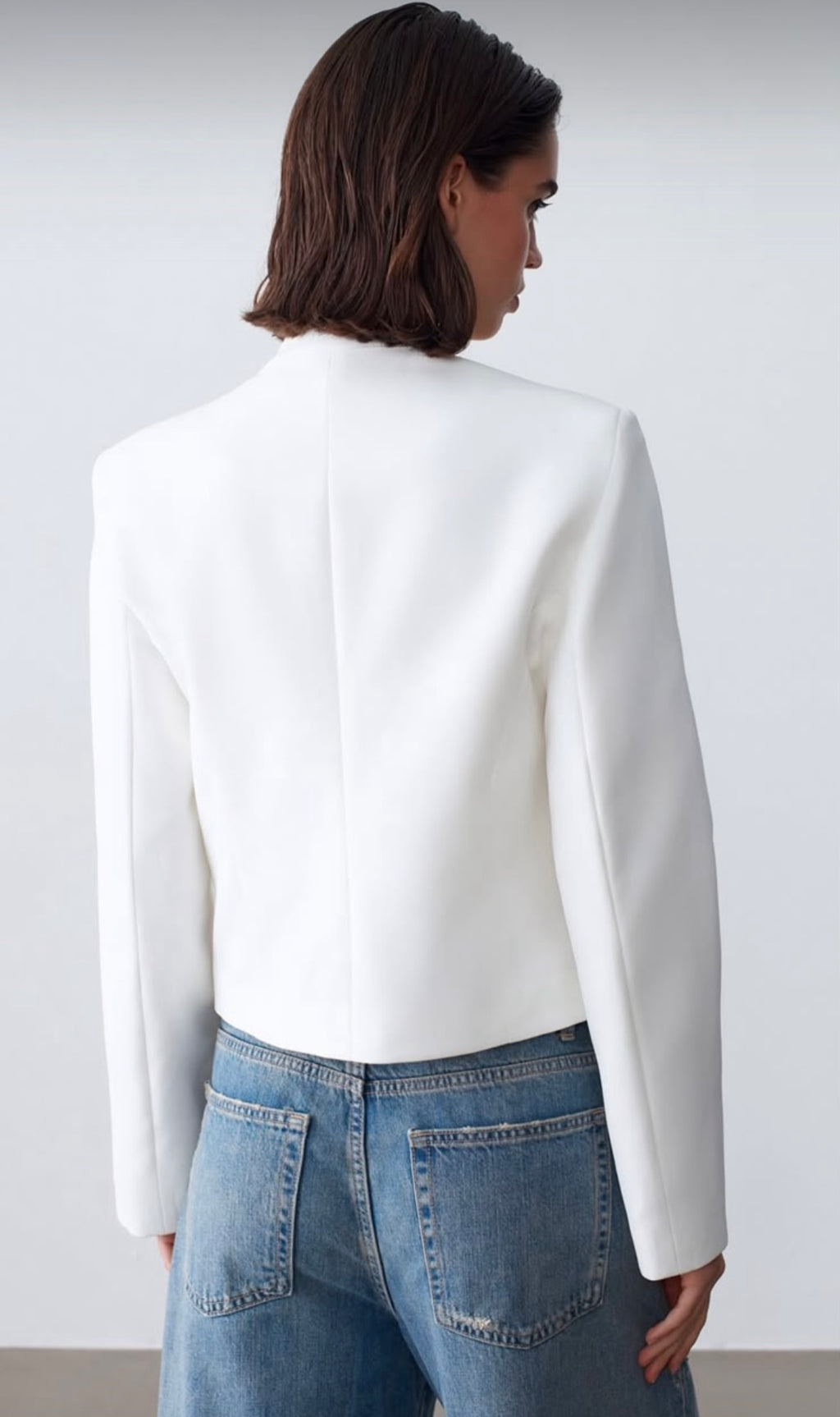 Fitted blazer with a metal clasp, lining, button details, shoulder pads, a round neck, and long sleeves