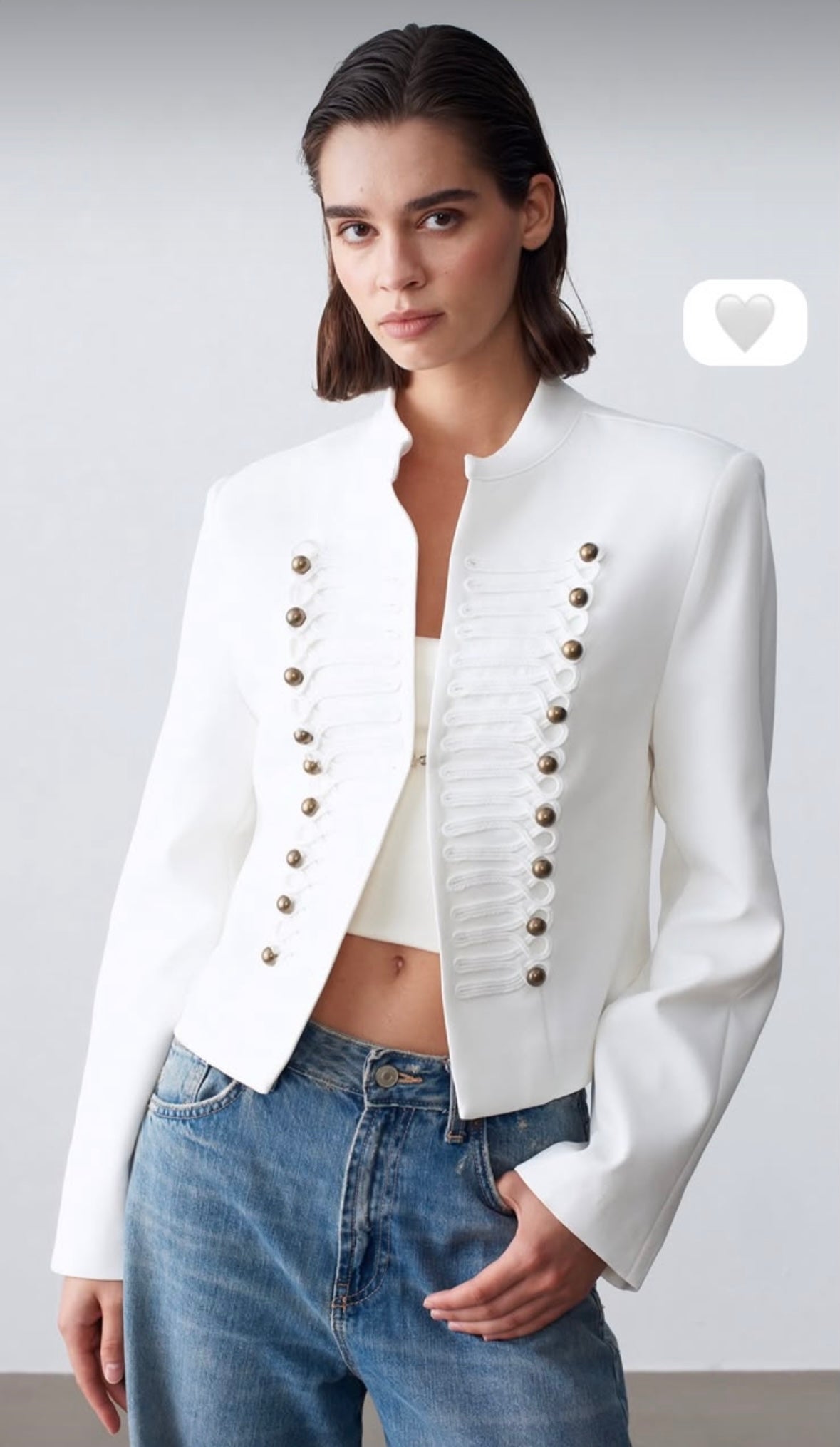 Fitted blazer with a metal clasp, lining, button details, shoulder pads, a round neck, and long sleeves