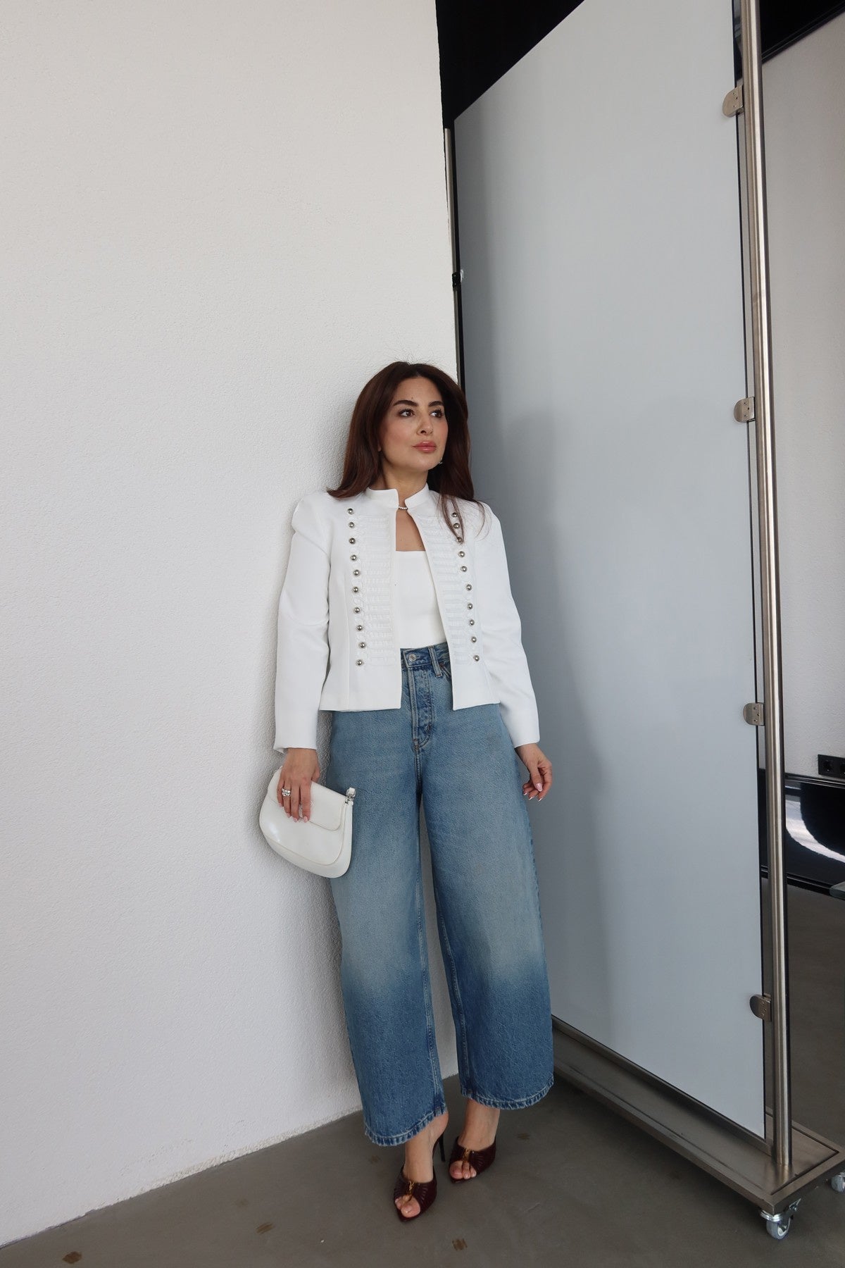 Fitted blazer with a metal clasp, lining, button details, shoulder pads, a round neck, and long sleeves