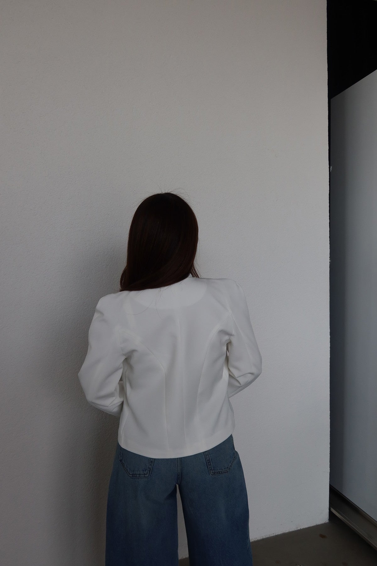 Fitted blazer with a metal clasp, lining, button details, shoulder pads, a round neck, and long sleeves
