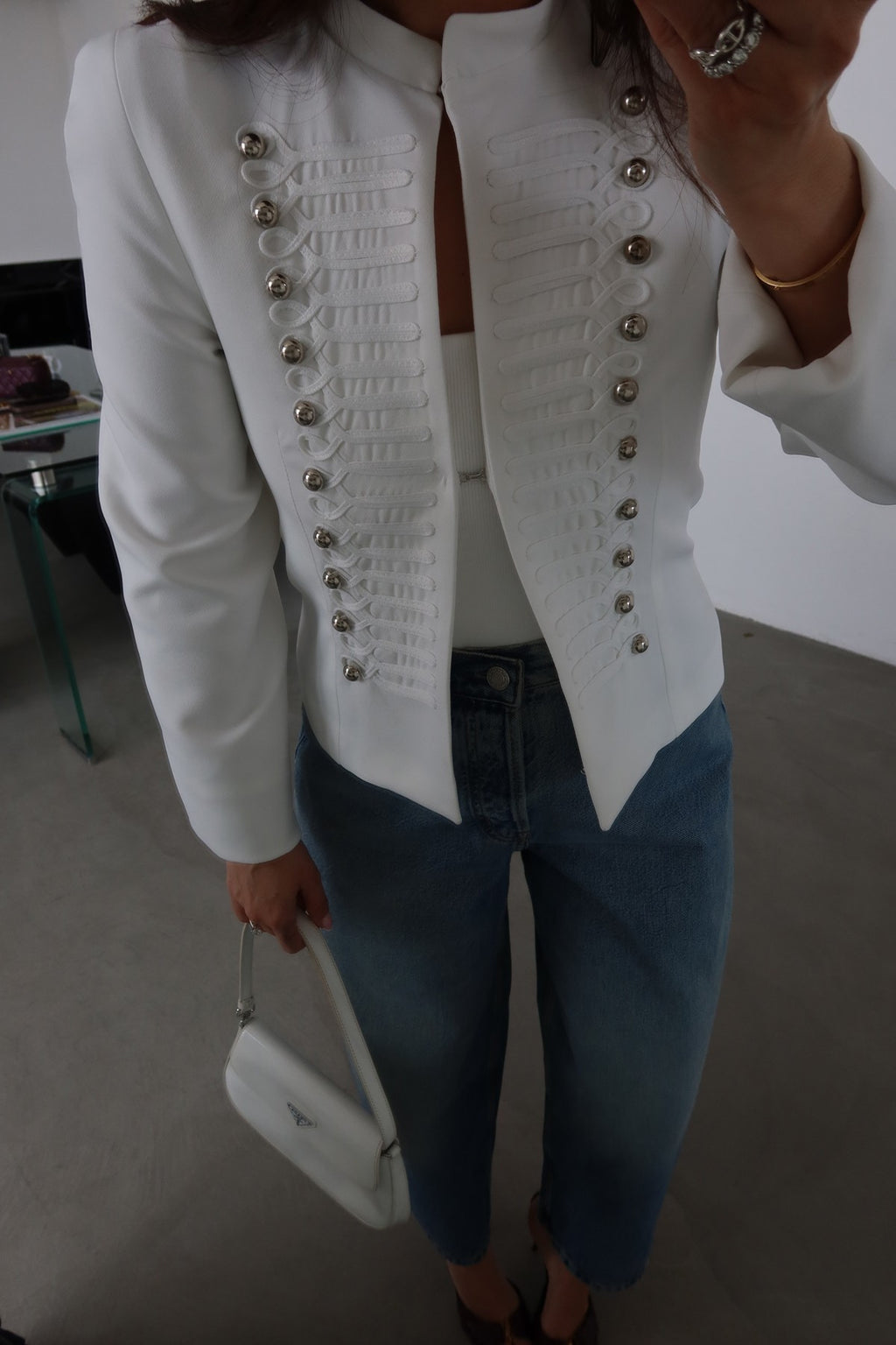 Fitted blazer with a metal clasp, lining, button details, shoulder pads, a round neck, and long sleeves