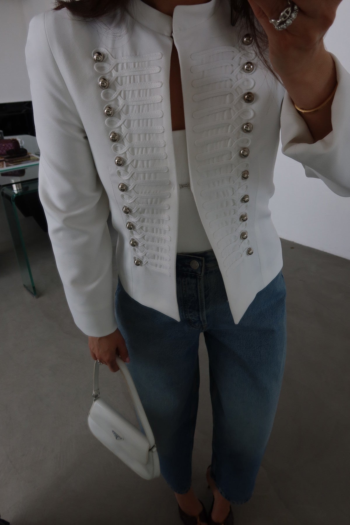 Fitted blazer with a metal clasp, lining, button details, shoulder pads, a round neck, and long sleeves